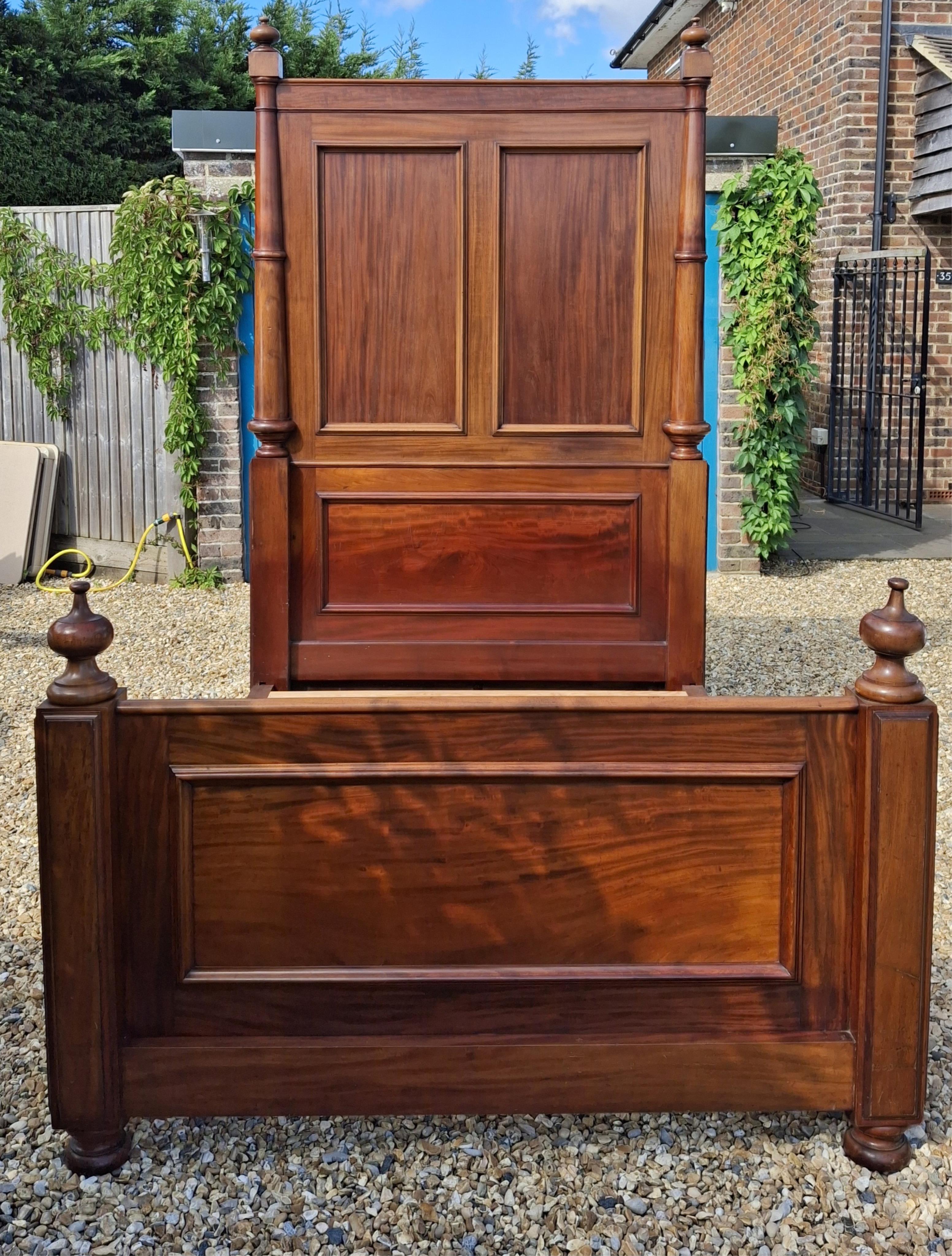 A Victorian mahogany bed frame, width 151cm, height 242cm accompanied by cream jacquard bed cover, cushions and bolsters